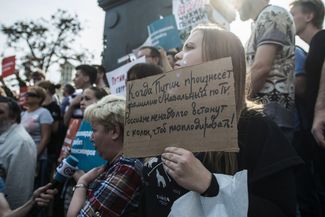 Sign reads, “When Putin speaks Navalny's name on TV, Russians will briefly rise from their knees to applaud!”