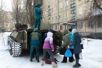 Военная техника увозит людей из жилого дома в Кировском районе Донецка, 1 февраля 2017 года