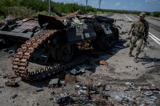 Украинский военный возле подбитого танка