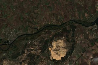 Вид со спутника на Херсон (на изображении он находится слева), расположенный внизу течения реки Днепр. Выше по течению — дамба Каховской ГЭС (на изображении справа). В Главном управлении разведки (ГУР) Минобороны Украины <a href="https://t.me/meduzalive/71790" rel="noopener noreferrer" target="_blank">утверждают</a>, что Россия ожидает быстрого продвижения украинских войск и планирует разрушить Каховскую ГЭС. Минировать ее, по заявлению украинского ГУРа, россияне начали еще в апреле. О том, что Россия готовится взорвать Каховскую ГЭС и обвинить в теракте Киев, ранее <a href="https://t.me/meduzalive/71700" rel="noopener noreferrer" target="_blank">заявили</a> в американском Институте изучения войны