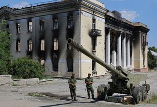 Военнослужащие ЛНР возле гаубицы на выставке украинской военной техники в Лисичанске, который в начале июля перешел под контроль РФ<br>