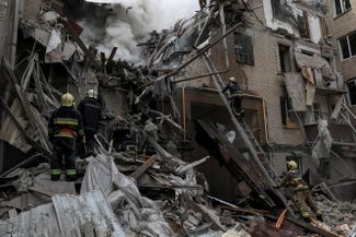 Пожарные на месте разрушенного ракетным ударом дома
