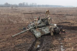 Украинские солдаты осматривают увязшую и брошенную российскую технику под Киевом
