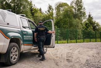 A Finnish border guard at a section of the initial stretch of fence under construction near Imatra, in southeast Finland. May 30, 2023.