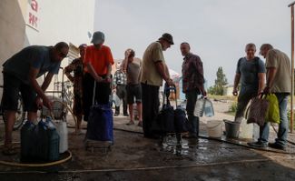 Местные жители в Рубежном набирают воду в ведра