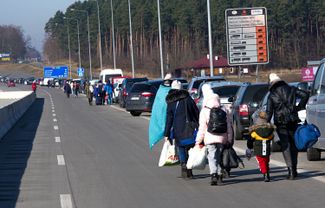 Женщины и дети пешком пересекают границу между Украиной и Польшей. Погранпереход Корчова—Краковец, 26 февраля 2022 года