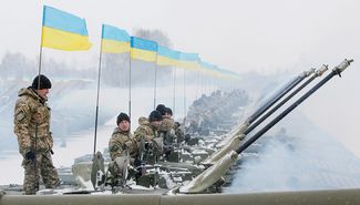 Ukrainian soldiers sit atop armored personnel carriers during a ceremonial handover of weapons, military equipment and aircraft to the army on a parade ground near Zhytomyr. January 5, 2015