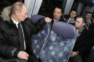 Владимир Путин и Александр Шпрыгин (слева у окна) в автобусе по пути на кладбище к могиле Егора Свиридова