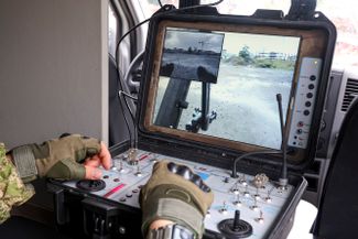 Член сборного отряда разминирования международного противоминного центра Вооруженных сил РФ управляет мобильным инженерным комплексом