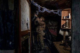 Украинский военный украшает позиции на линии фронта перед Новым годом. 