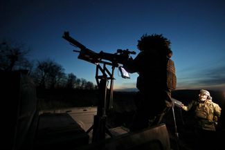 Боец зенитной огневой группы выслеживает цель в ночном небе с помощью специального видеоприцела, установленного на пулемете. Харьковская область