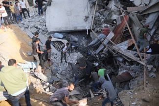Поиск выживших под обломками разрушенного здания в городе Хан-Юнис на юге сектора Газа. 11 октября 2023 года