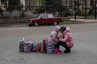 Мать с дочерью ждут автобуса, который должен отвезти их из Славянска Донецкой области в Ровно на западе Украины.<br>