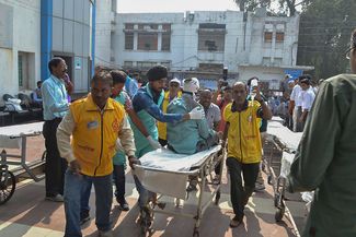Пострадавший пассажир сошедшего с рельсов пассажирского поезда около больницы в городе Канпуре на севере Индии. 20 ноября 2016 года