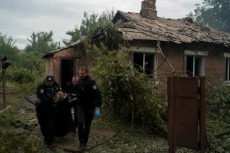 Полицейские несут тело жителя Покровска Донецкой области, погибшего в результате российского обстрела города в ночь с 11 на 12 сентября. Украинские СМИ сообщают о шести жертвах