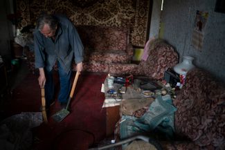 70-летний житель Краматорска Владимир Чаплинский наводит порядок в своей квартире после российского ракетного удара