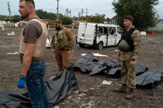Украинские военные возле тел жителей Запорожья, погибших под обстрелом 30 сентября