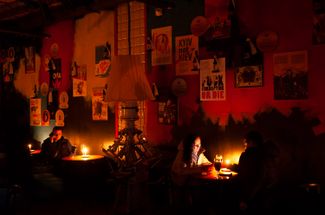 Посетители ресторана во Львове ужинают при свечах из-за отключений электричества. Ноябрь 2022 года