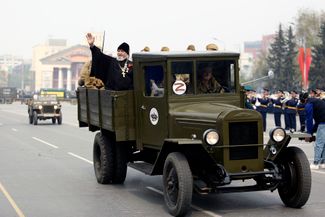 Православный священник приветствует жителей Омска из кузова советского военного автомобиля ЗИС-5 (его также называют «трехтонка»)