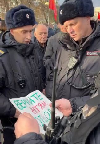Полицейские забирают плакат митингующих во время акции в Мосве, 7 ноября 2023 года