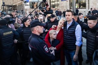 Полицейские выводят семью Навальных с митинга против реновации в Москве. 14 мая 2017 года