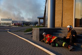Пожарные, работающие у гипермаркета, пытаются укрыться во время воздушной тревоги