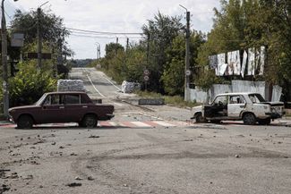 Поврежденные снарядами автомобили недалеко от центра Купянска