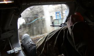 A DNR soldier in an armored vehicle on a street in Uglegorsk. February 2015