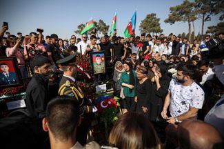 Жители Азербайджана у могилы военнослужащего Сабухи Ахмедова на кладбище возле Баку во время похорон азербайджанских военнослужащих, погибших в ходе столкновений с армянскими войсками на границе с Арменией. 14 сентября 2022 года