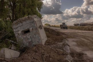 Ukrainian soldiers drive an armored vehicle past a destroyed border crossing point in Ukraine’s Sumy region. August 14, 2024.