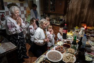 Семья Зеленчуков молится перед рождественским ужином в своем доме в селе Криворивня Ивано-Франковской области в западной части Украины