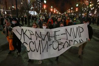 Demonstrators march with a banner that reads “Peace for Ukraine, Freedom for Russia” in Moscow, Thursday, Feb. 24, 2022, on the evening of Russia’s early-morning attack on Ukraine. Hundreds of people gathered to protest in Moscow’s city center, as well as in cities across Russia, and many were arrested. 