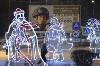 Новогодние украшения в Санкт-Петербурге на фоне рекламы контрактной службы в российской армии, 12 декабря 2023 года.