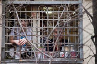 Митинг 5 декабря 2011 года перерос в стихийное шествие в сторону здания ЦИК на Лубянской площади. Полиция задержала более 300 активистов, в том числе и Навального. Его впервые арестовали на 15 суток. На фотографии, сделанной 12 декабря 2011-го, Навальный (справа) и еще один арестованный выглядывают на улицу из окна своей камеры