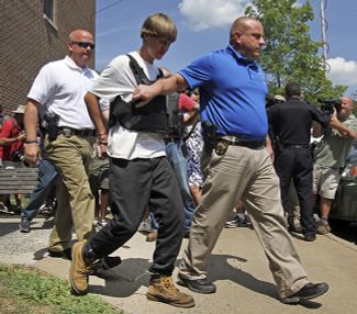 Полиция ведет Дилана Руфа (второй слева), который подозревается в нападении на церковь в Чарльстоне, 18 июня 2015 года
