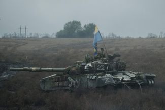 Украинский флаг на подбитом российском танке.