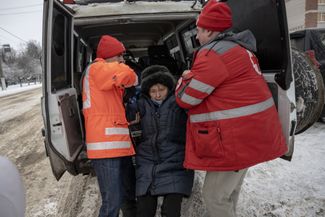 Сотрудники Красного Креста помогают 49-летней Светлане и ее 77-летней матери Людмиле во время эвакуации из Купянска Харьковской области — город находится всего в нескольких километрах от линии боевого соприкосновения