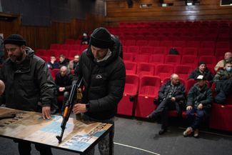 Волонтер учится обращаться с автоматом в львовском кинотеатре. 5 марта 2022 года