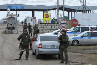 Russian border guards at a vehicle checkpoint in Dzhankoi, a town between Russian-occupied Crimea and the rest of Ukraine