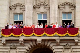 Карл III и королева Камилла машут с балкона Букингемского дворца жителям Лондона. Вместе с ними на балконе — принц Уильям и Кейт Миддлтон с детьми, принцесса Анна и принц Эдвард