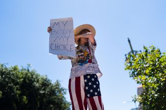 Участница акции протеста в Лос-Анджелесе с плакатом: «Мое тело — мой выбор»