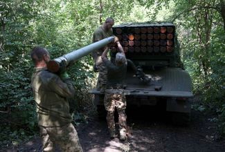 Украинские артиллеристы загружают ракеты на самоходную 122-миллиметровую реактивную систему залпового огня БМ-21 «Град» под Бахмутом