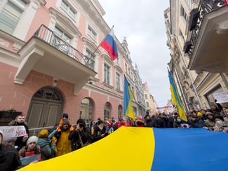 На узкую улицу Пикк, на которой находится посольство России в Таллине, вышли десятки людей с огромным флагом Украины
