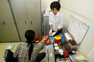 Медсестра берет кровь у участника испытаний вакцины AIDSVAX B/E, вошедшей потом в состав «тайской вакцины». 2002 год