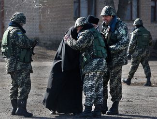 A priest bestows his blessing upon Ukrainian border guards in Alekseevka. March 21, 2014.