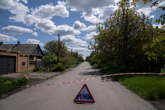 Знак с надписью «Мины» на дороге в селе Максимильяновка. Здесь после обстрела российских войск были обнаружены неразорвавшиеся снаряды
