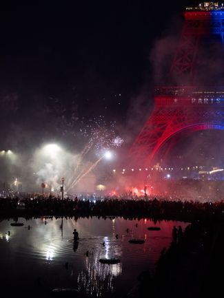 Fans set off fireworks near the Eiffel Tower