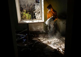 Жительница Николаева убирается в своей квартире, пострадавшей от обстрелов