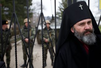 Archbishop Kliment of the Kyiv Patriarchate of the Ukrainian Orthodox Church standing next to the gates to a Ukrainian military base in the village Perevalnoe in Crimea. March 2, 2014.