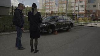 Igor Zhulimov shows a witness his car, which had its tires slashed